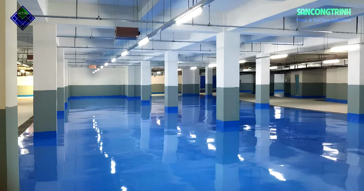 Sàn epoxy màu xanh hoàn thiện trong tầng hầm với bề mặt bóng phản chiếu ánh sáng sau thi công