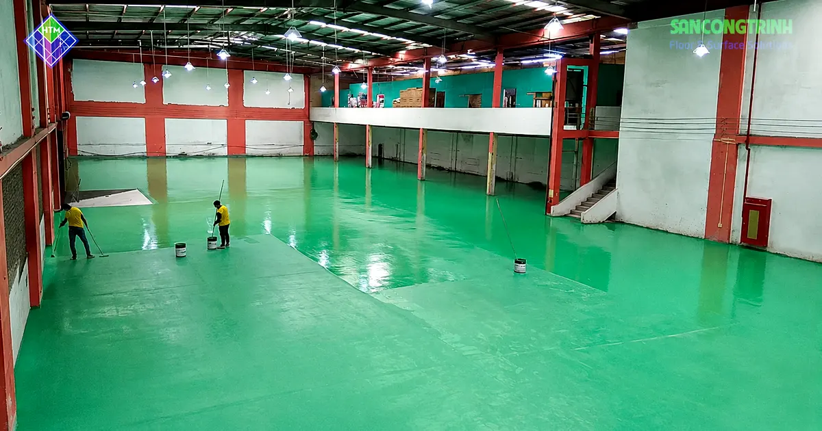Kỹ thuật viên thi công sơn epoxy màu xanh cho sàn nhà xưởng công nghiệp tại Hải Phòng